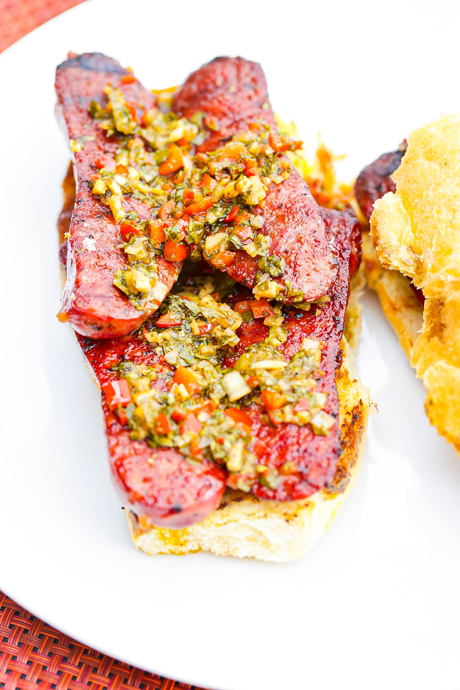 open face choripan sandwich on a white plate