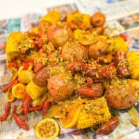 crawfish boil with sauce piled on newspaper