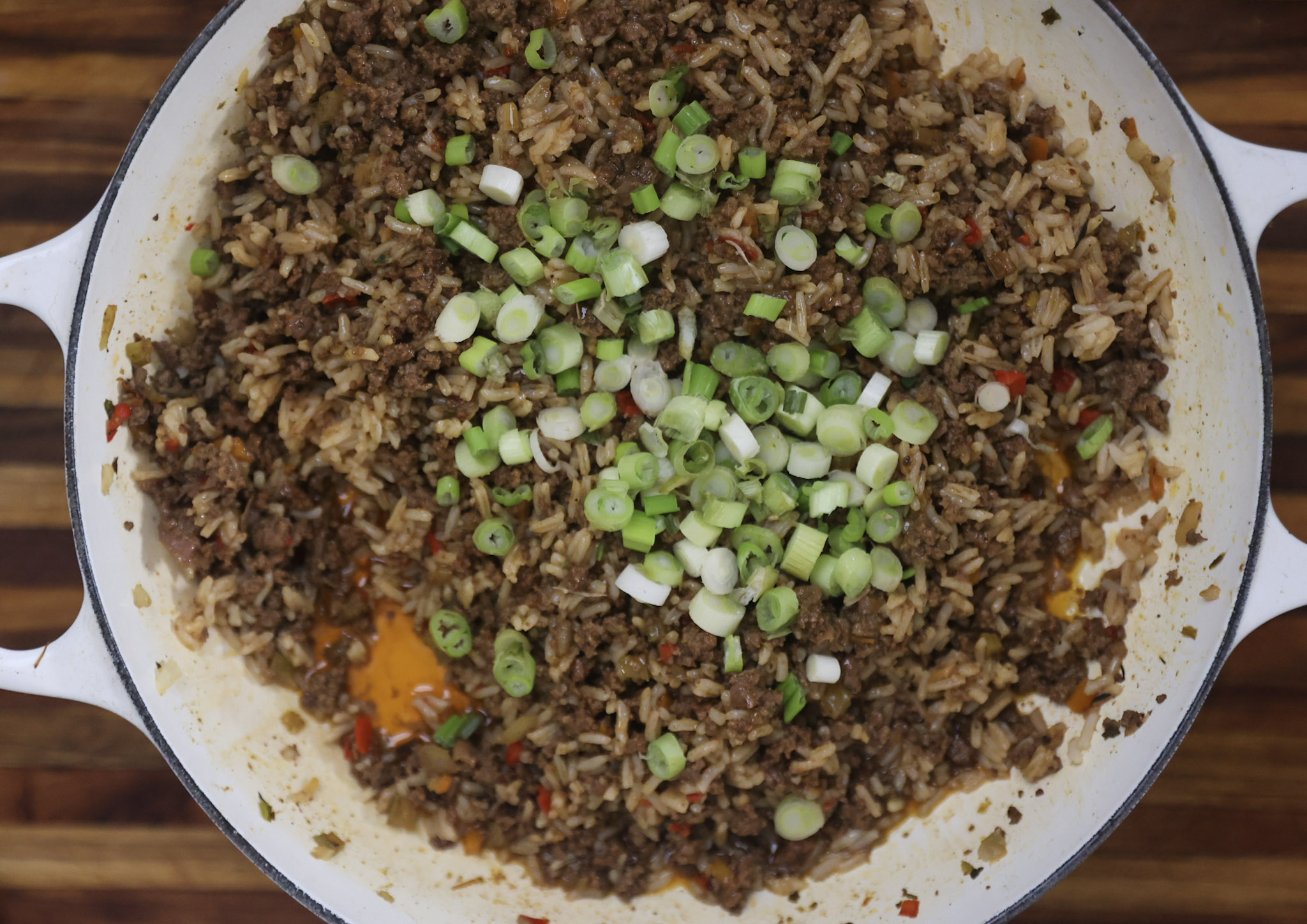 green onions added to dirty rice mix cooking