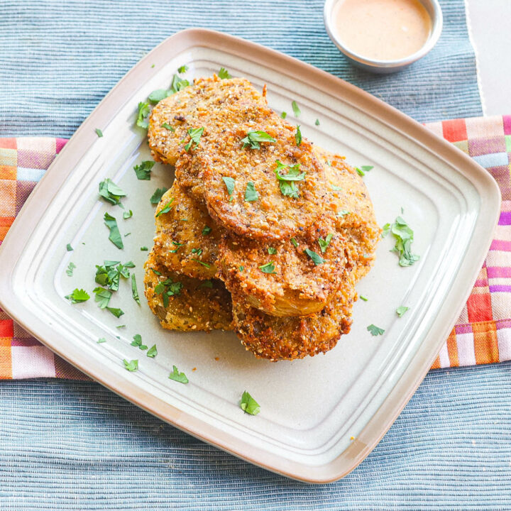 crispy fried green tomatoes stacked on square plate
