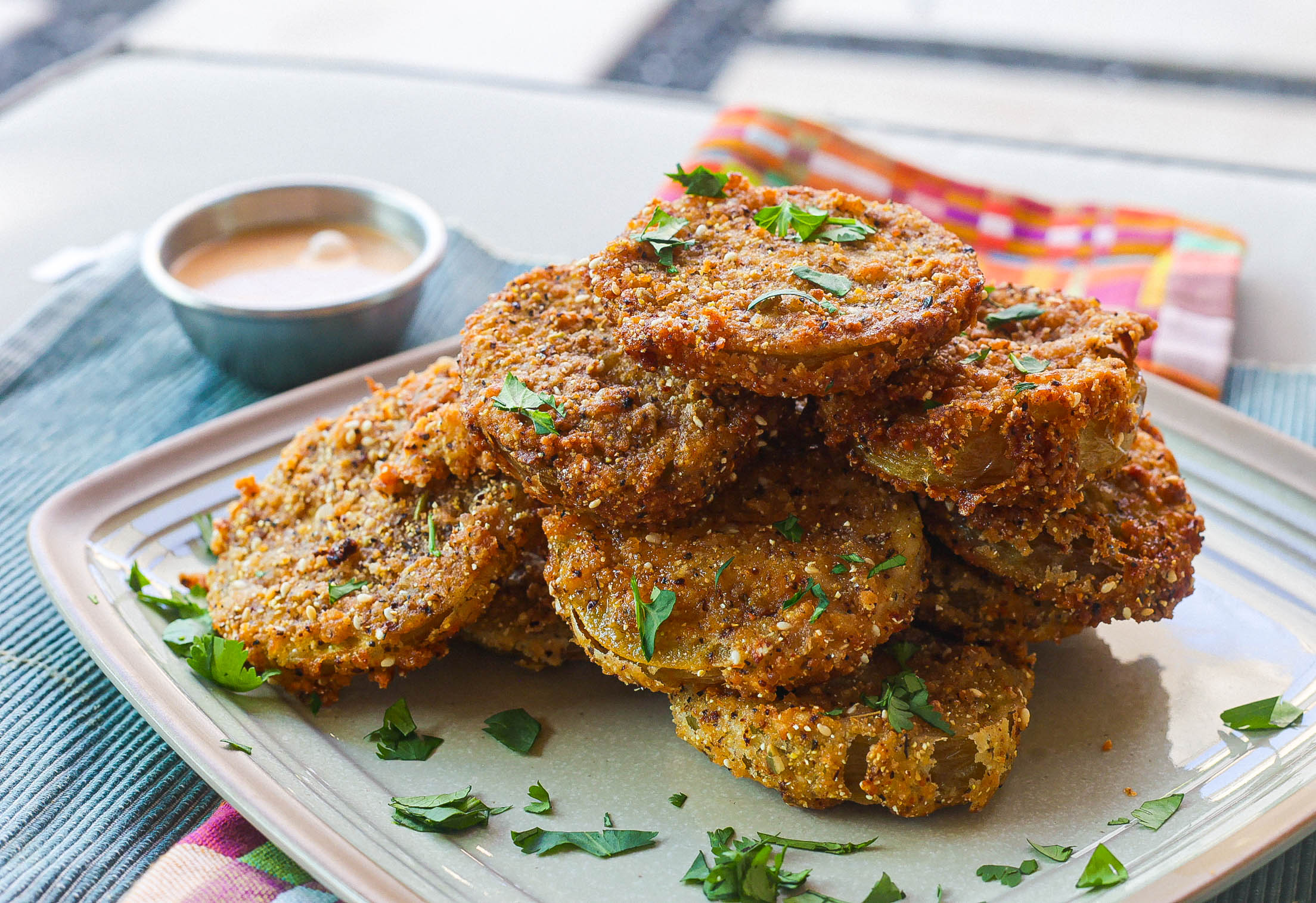 crispy fried green tomatoes stacked on square plate