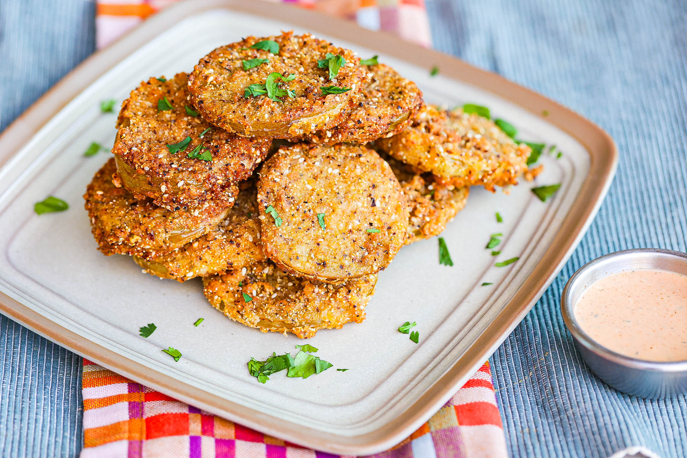 crispy fried green tomatoes stacked on square plate