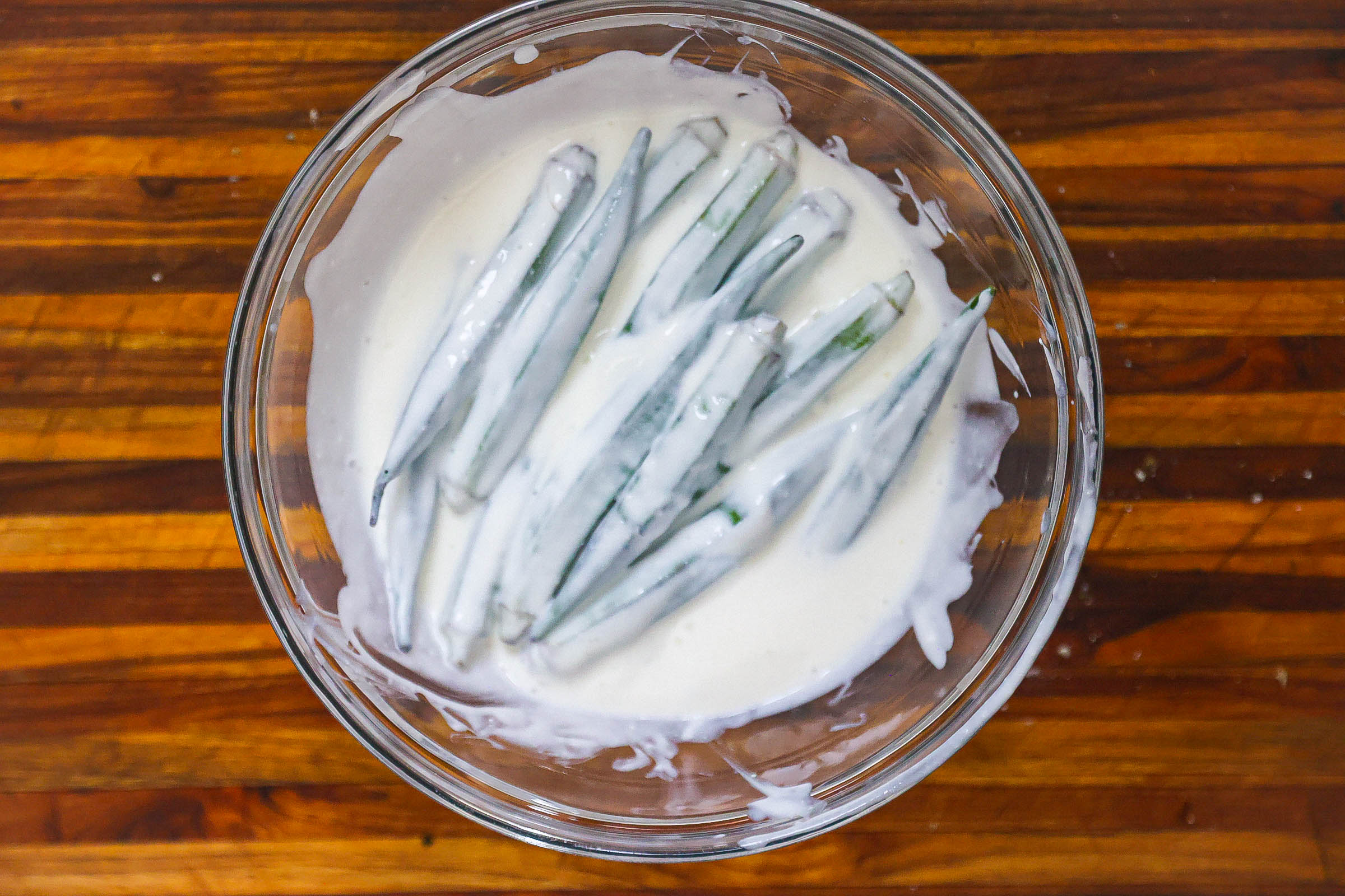 whole okra marinating in buttermilk