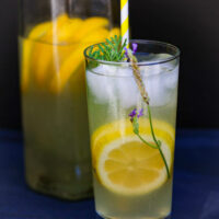 glass of lavender lemonade in front of a pitcher
