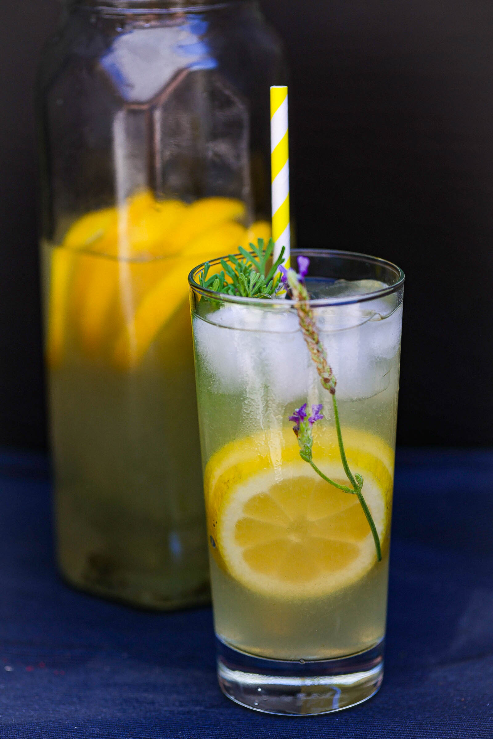 glass of lavender lemonade in front of a pitcher