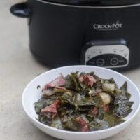 slow cooker collard greens with ham hocks in white bowl