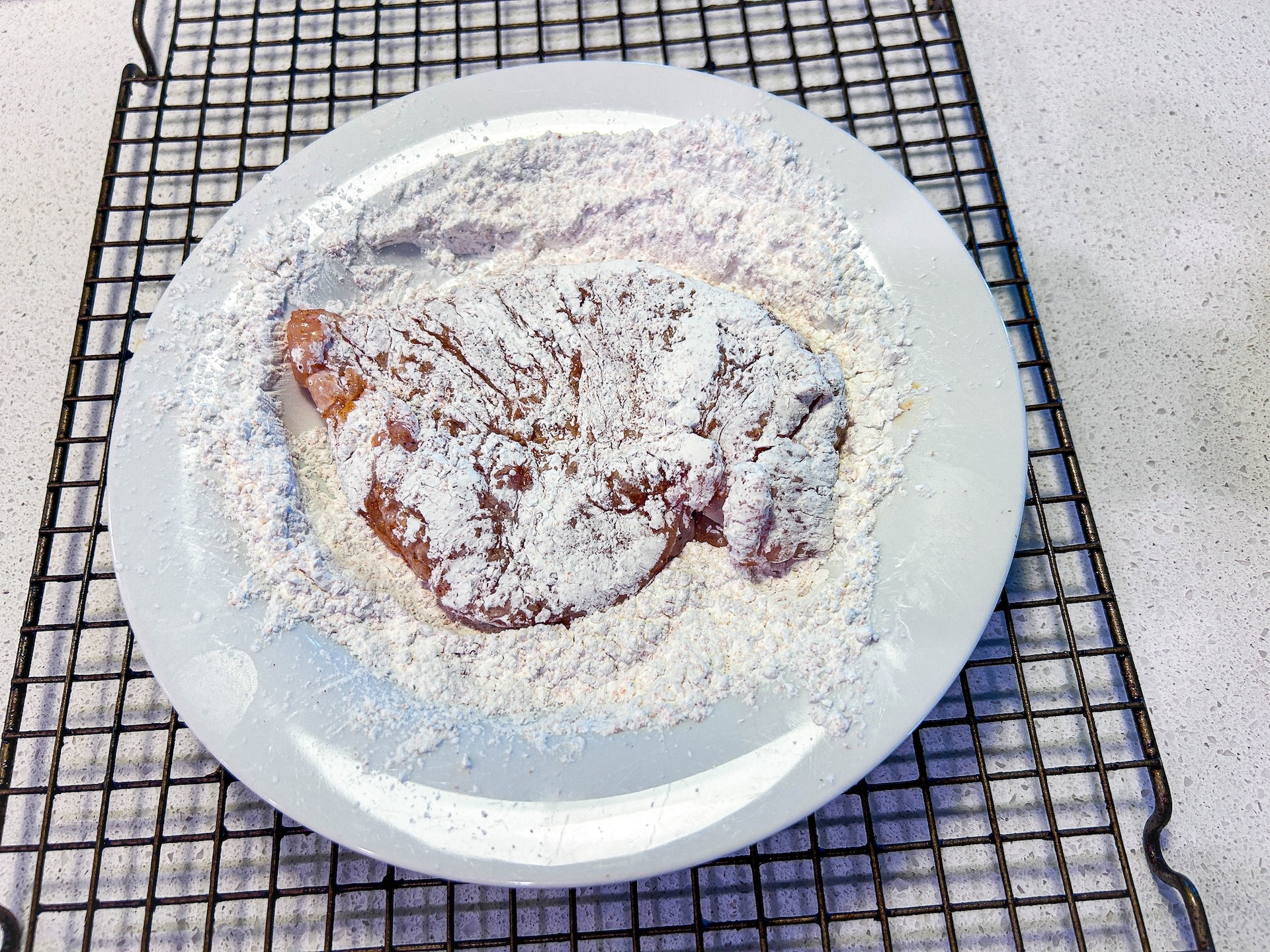 chicken coated in flour on white plate