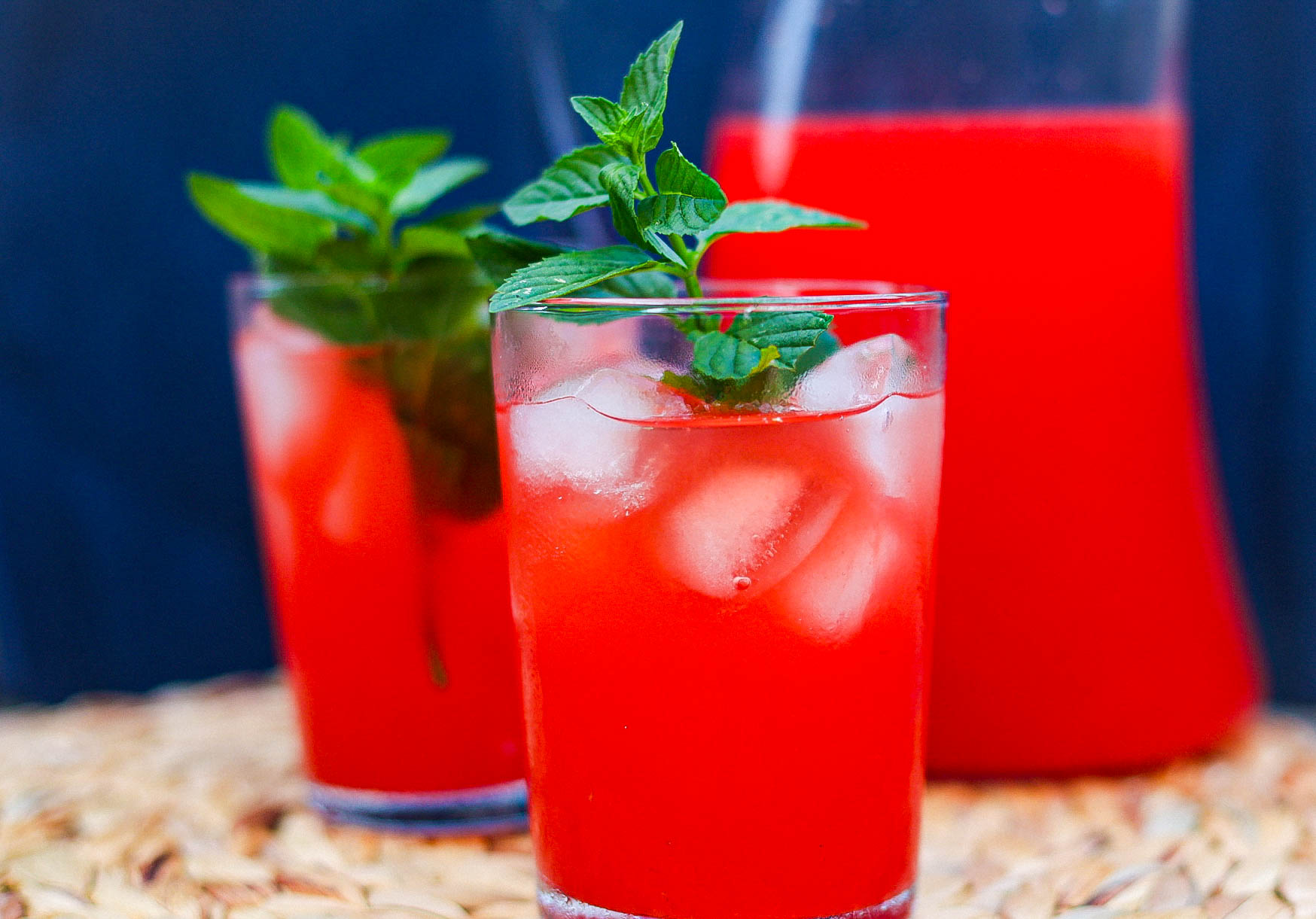 rum punch in two glasses plus a tall pitcher